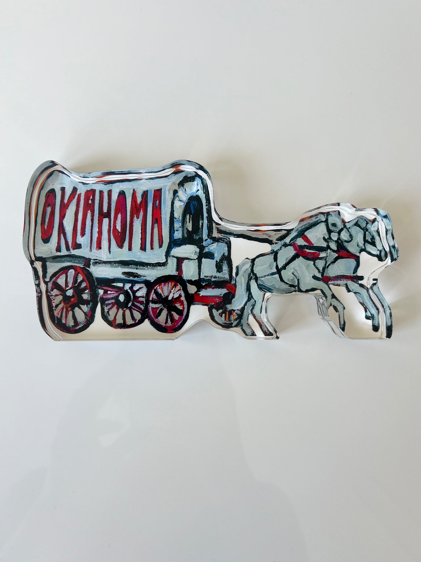 An acrylic tabletop shelfie of a horse and carriage from Oklahoma University.