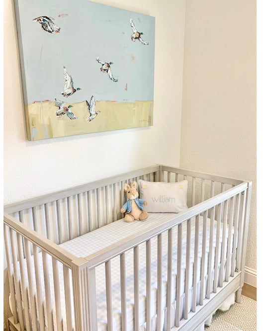 Duck canvas print featuring original artwork by Chelsea McShane displayed in a blue and white nursery above a crib.