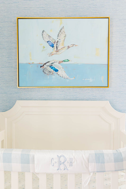 Duck canvas print featuring original artwork by Chelsea McShane displayed in a blue and white nursery above a crib.